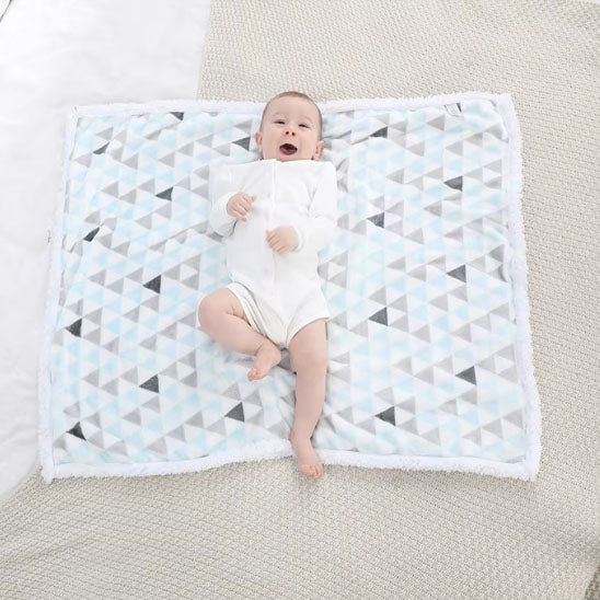 bébé heureux sur couverture emmaillotage