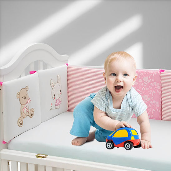 bébé joue dans son lit avec tour de lit bébé