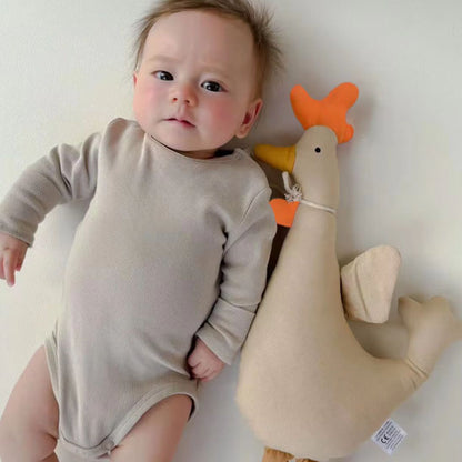bébé allongé près doudou coq