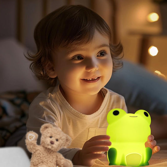 fillette heureuse avec veilleuse bébé grenouille