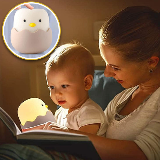 maman et bébé regardant un livre avec la veilleuse bébé